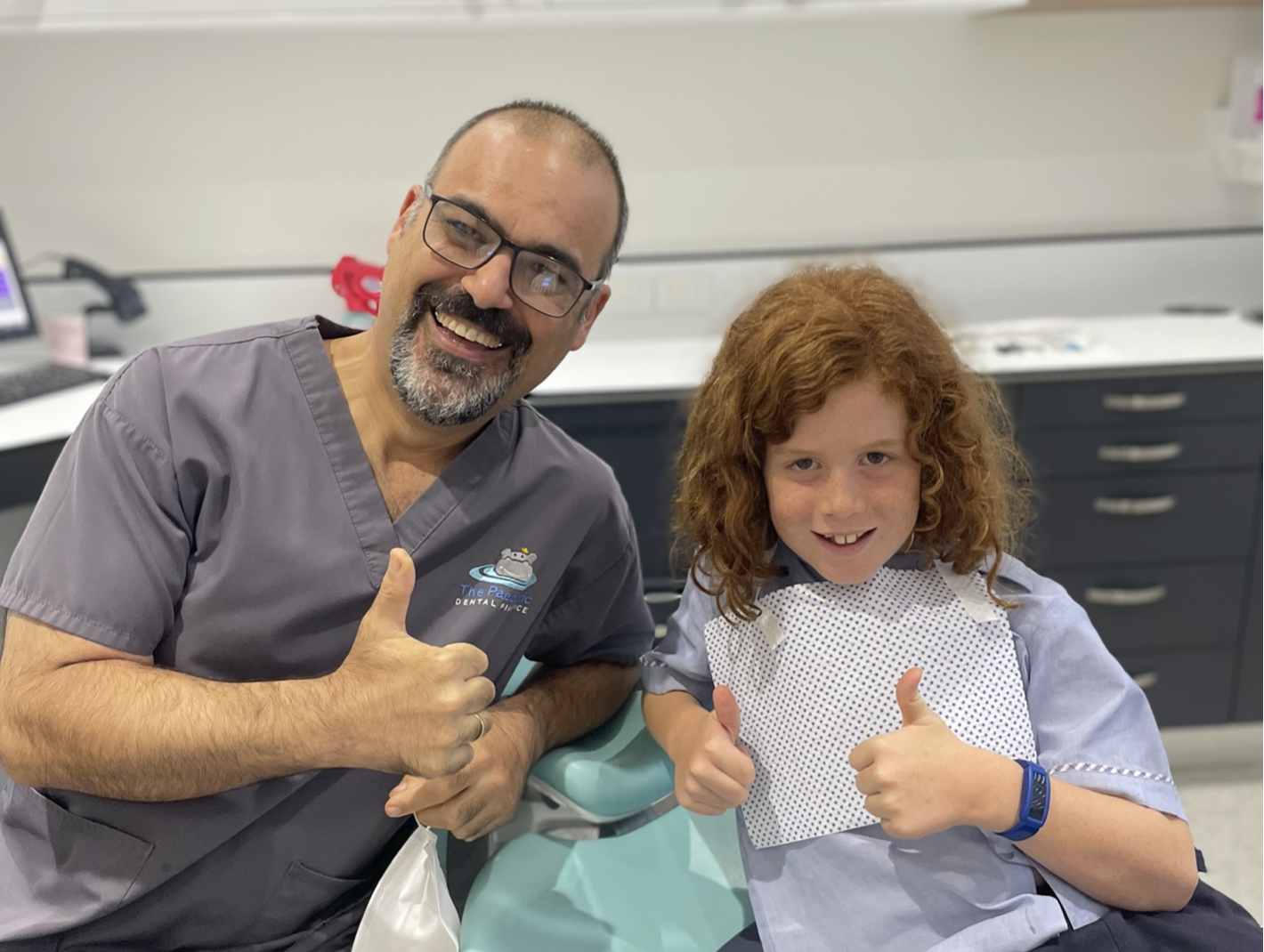 Dr Michael Chong, Oral Health Therapist Dana having fun with child patient.